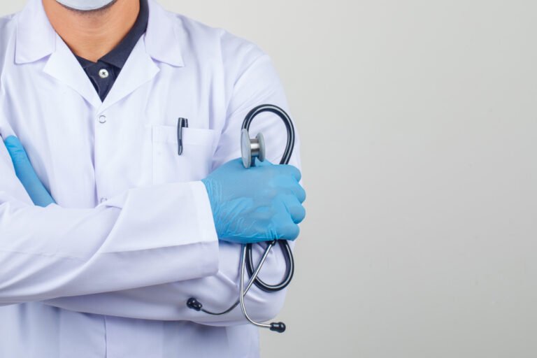 doctor crossing arms while holding stethoscope white coat