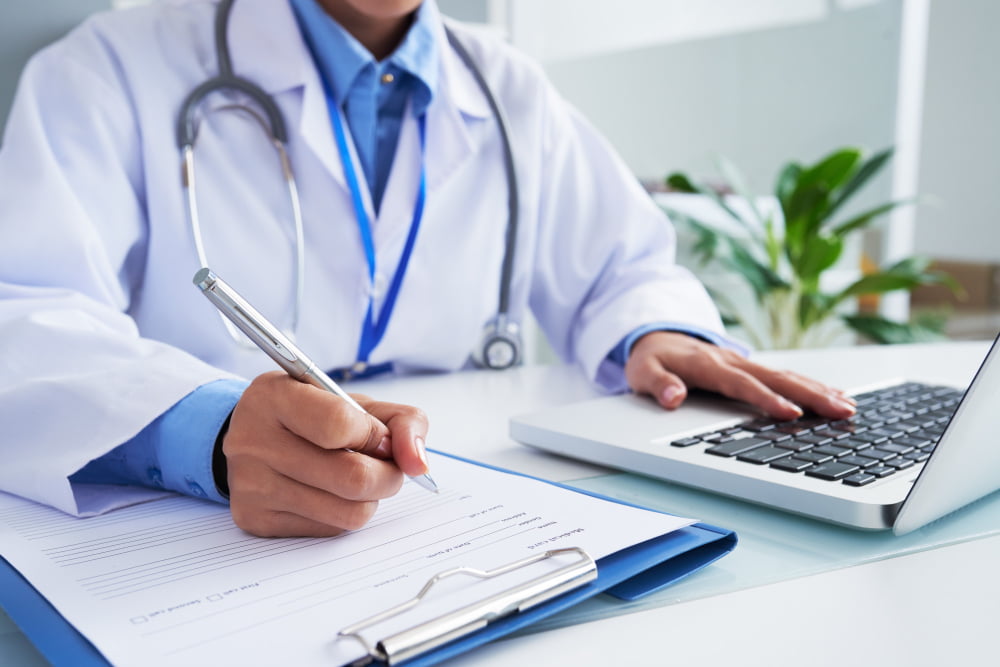 O que é estimulante e para que são usados? 2 hands unrecognizable female doctor writing form typing laptop keyboard 2