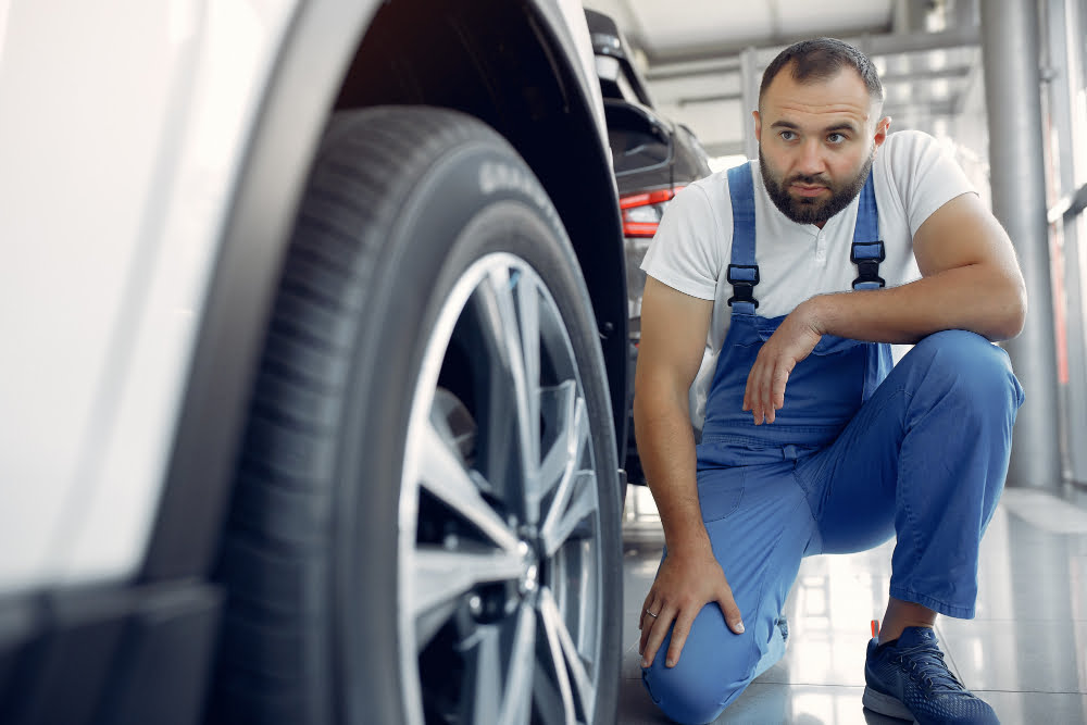 Comprar pneu pela internet vale a pena? 2 handsome man blue uniform checks car
