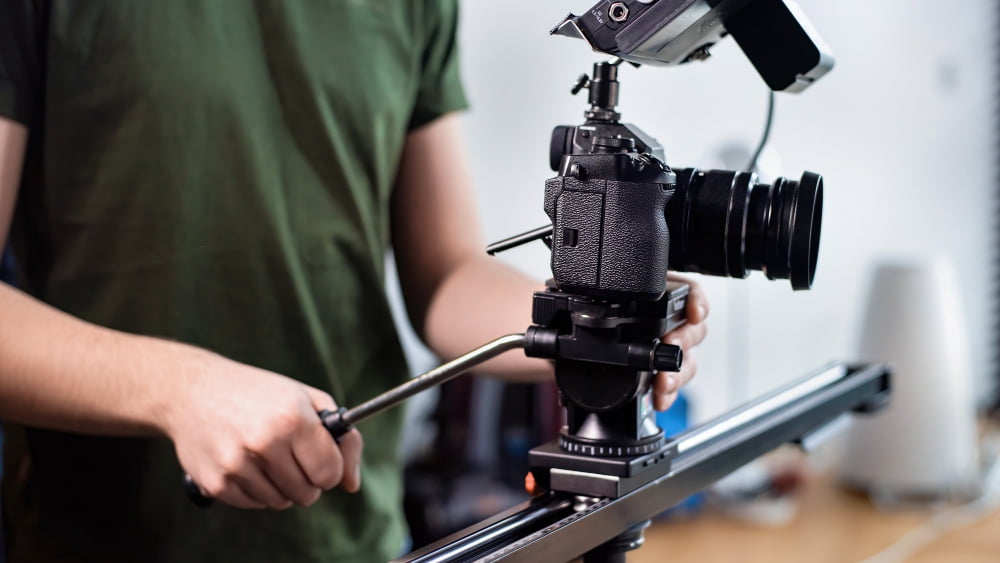Quais são as maiores empresas de filmes? 2 young content creator man filming with camera slider professional rig
